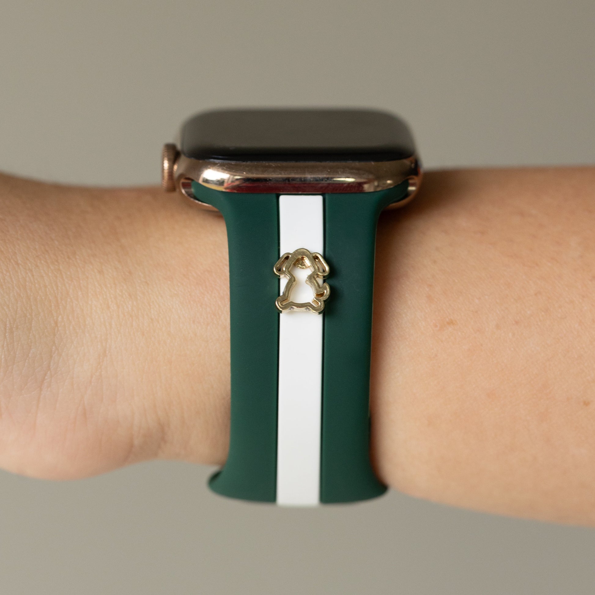 Smartwatch with a green and white band on a wrist against a neutral background