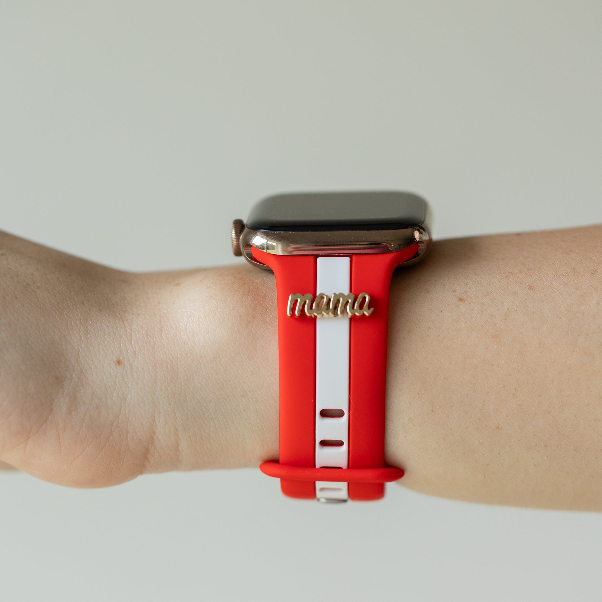 Smartwatch with a red band labeled 'mama' on a neutral background