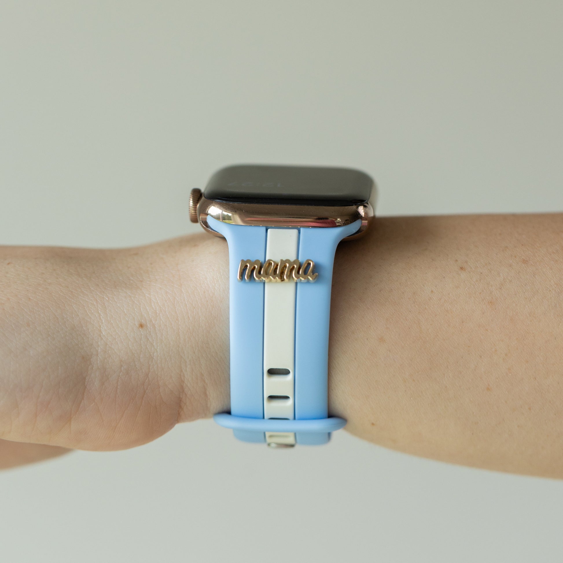 Smartwatch with a blue strap on a wrist against a neutral background